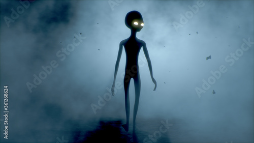 Valokuva Scary gray alien walks and looks blinking on a dark smoky background