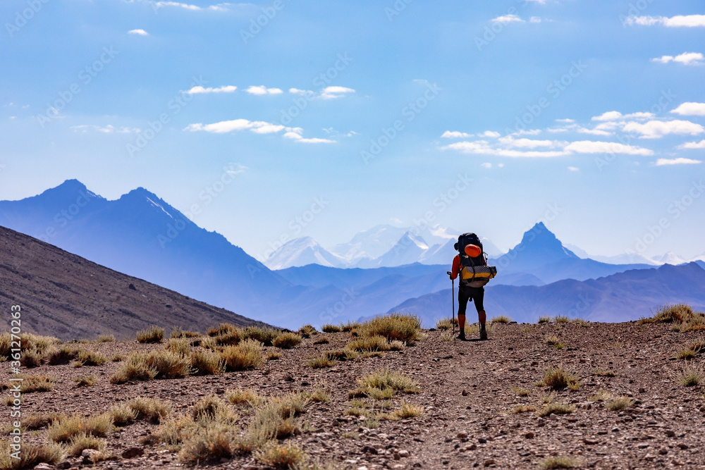 Tourist in the Pamir mountains on the background of Lenin Peak. Tajikistan.