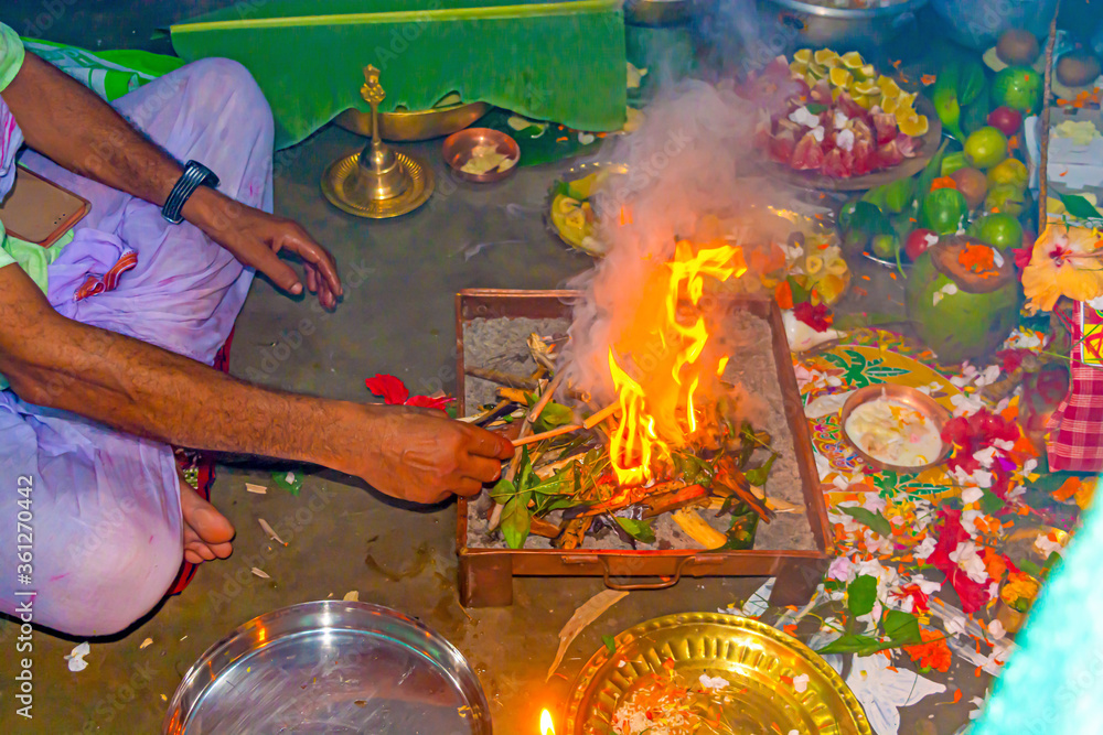 Hand of a hindu brahmin priest worshiping hindu God by performing yajna ...