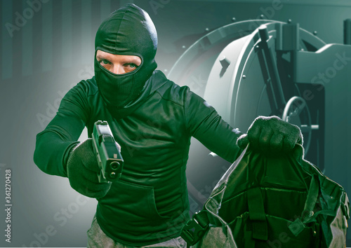 Photography heist and robbery - Hollywood style portrait of man in balaclava mask holding gu