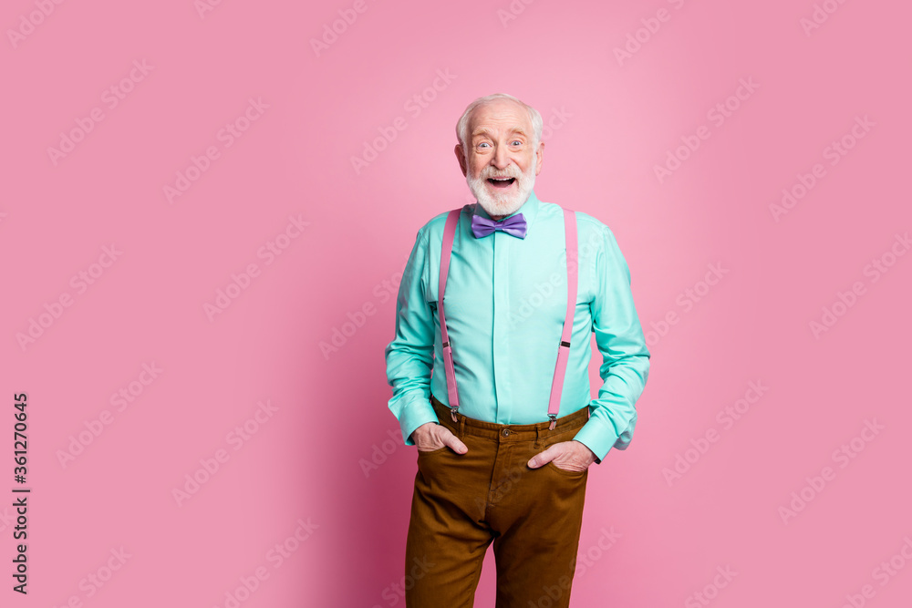 Photo of funny aged grandpa good mood standing self-confident hands pockets open mouth wear mint shirt suspenders bow tie brown pants isolated pink pastel background Photo of funny aged grandpa good mood standing self-confident hands pockets open mouth wear mint shirt suspenders bow tie brown pants isolated pink pastel background