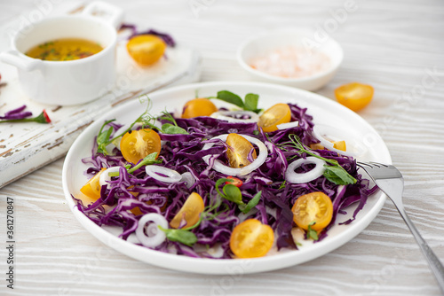 salad of red cabbage, yellow cherry tomatoes and onions