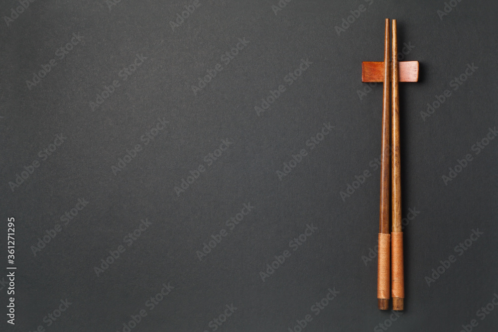 Top view of wooden chopsticks on black paper background