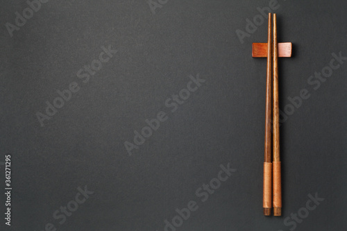 Top view of wooden chopsticks on black paper background © koosen