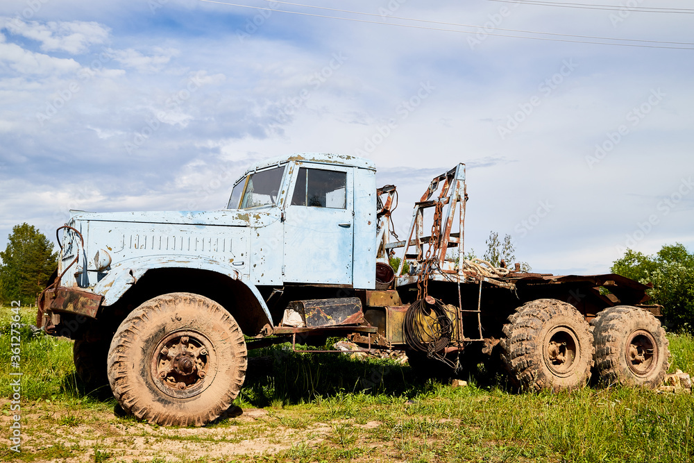 Dirty truck on a country green grass in a sunny summer day with blue sky. Dirty truck on a country green grass in a sunny summer day with blue sky.
