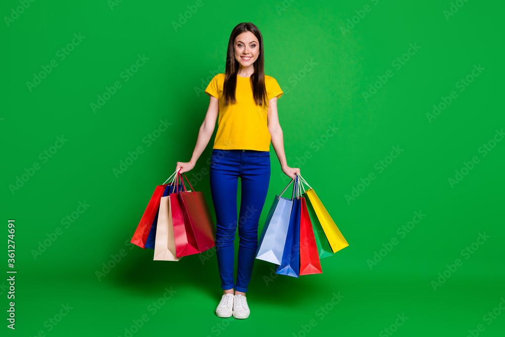 Full length body size view portrait of nice attractive pretty cute fashionable cheerful slim fit girl holding in hands carrying new things isolated bright vivid shine vibrant green color background Full length body size view portrait of nice attractive pretty cute fashionable cheerful slim fit girl holding in hands carrying new things isolated bright vivid shine vibrant green color background