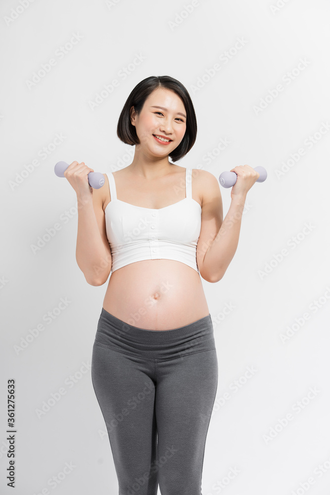 Pregnant woman lifting dumbbell on white background Pregnant woman lifting dumbbell on white background