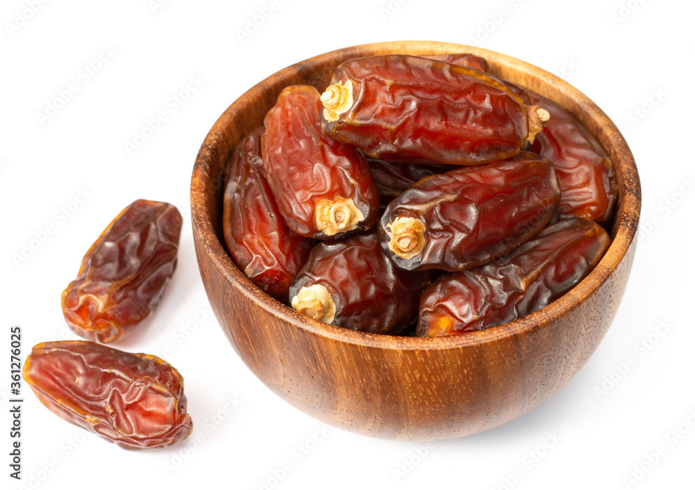 dried date palms in the wooden bowl, isolated on white background dried date palms in the wooden bowl, isolated on white background