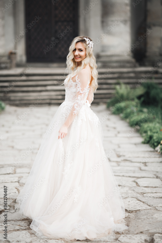 Obraz premium Beautiful bride spinning with perfect dress in the park