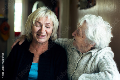 Portrait of a mature woman fooling with her old mother.