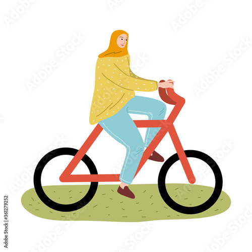 Young smiling muslim woman in hijab and sport clothing riding bike
