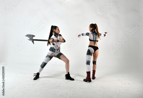 beautiful girls in costumes of robots quarreled and fight with a battle ax and a war hammer © константин константи