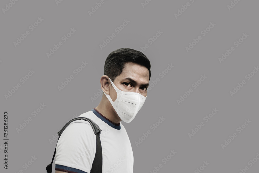 Portrait of man wearing protective mask in grey background during covid-19. Portrait of man wearing protective mask in grey background during covid-19.