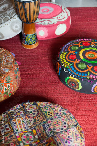 A Turkish traditional drum stands on the floor among bright bright puffs.