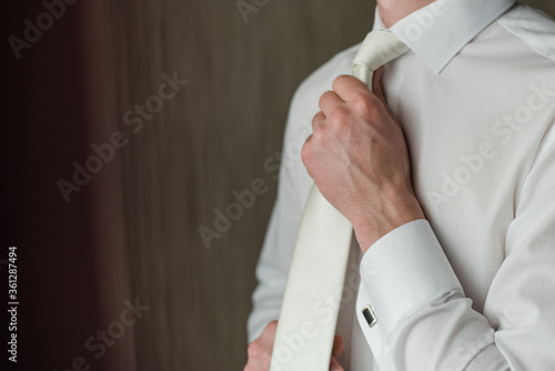man tightens his tie, white tie, wedding day, man in a white shirt, groom fees, White shirt