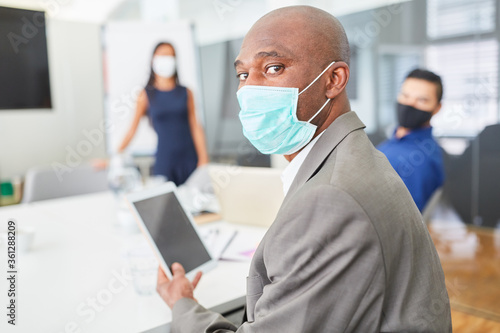 African business man with mask in a meeting
