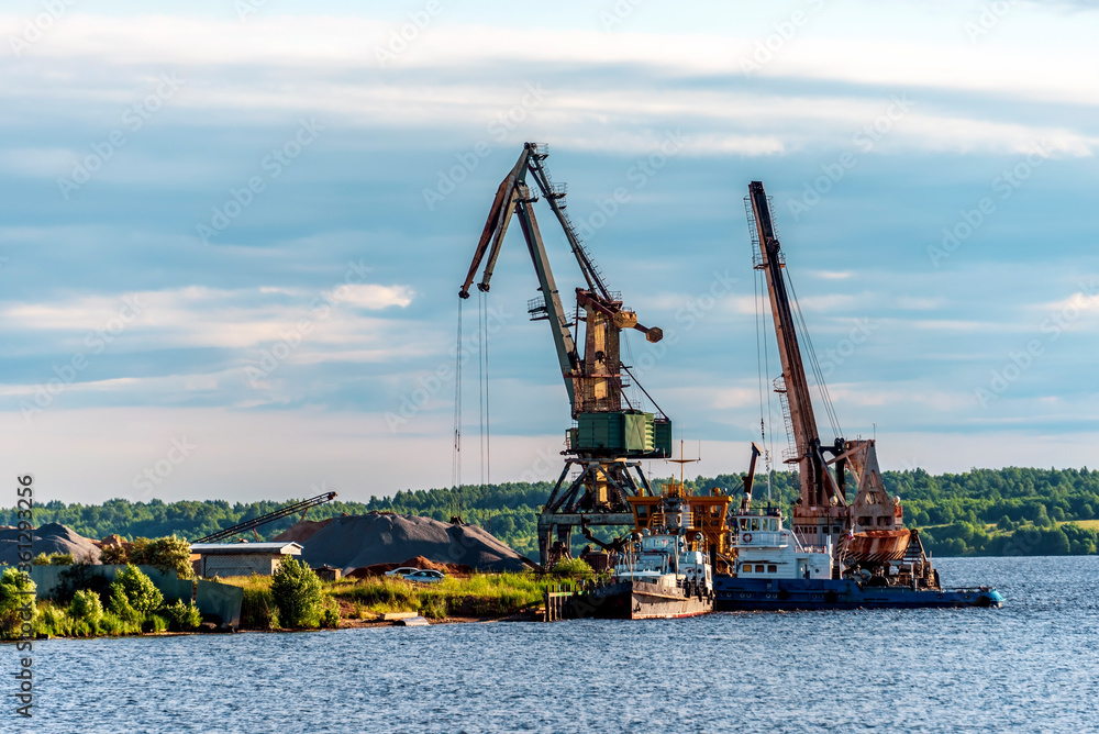 River embankment with cranes for unloading barges