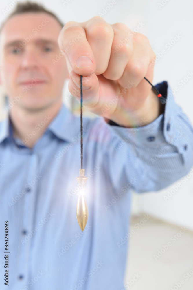Man using metal pendulum Man using metal pendulum