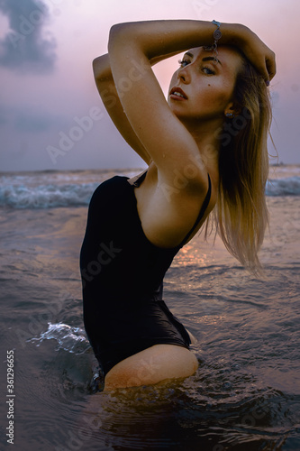 Girl posing in swimwear on the beach in water