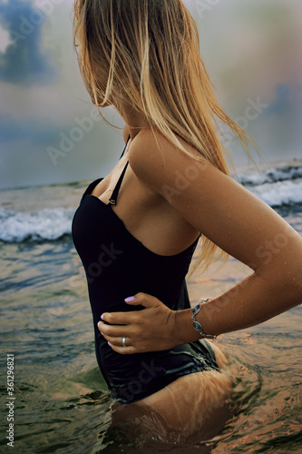 Girl posing in swimwear on the beach in water