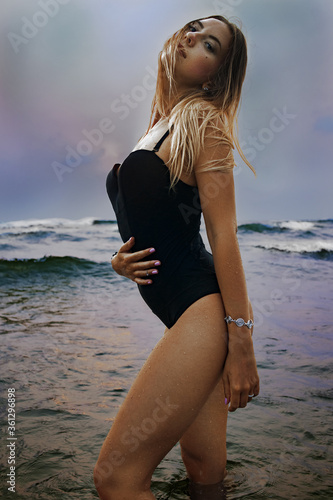 Girl posing in swimwear on the beach in water