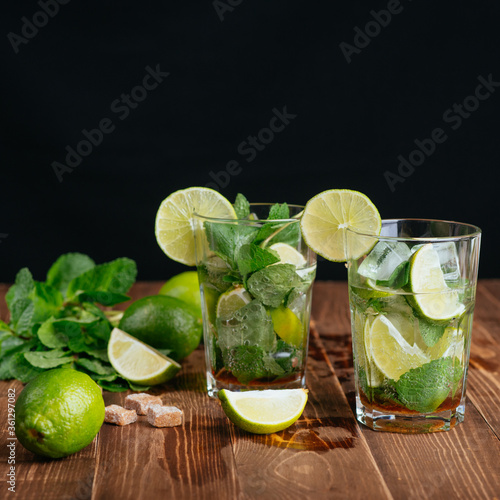 mojito cocktail with lime and mint on black background