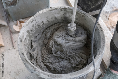 worker kneads cement mortar in a bucket
