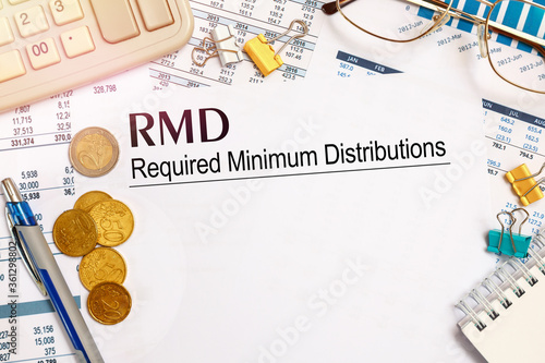 Desktop office desk, notebook, glasses, pen and documents with RMD require minimal distribution on the heading