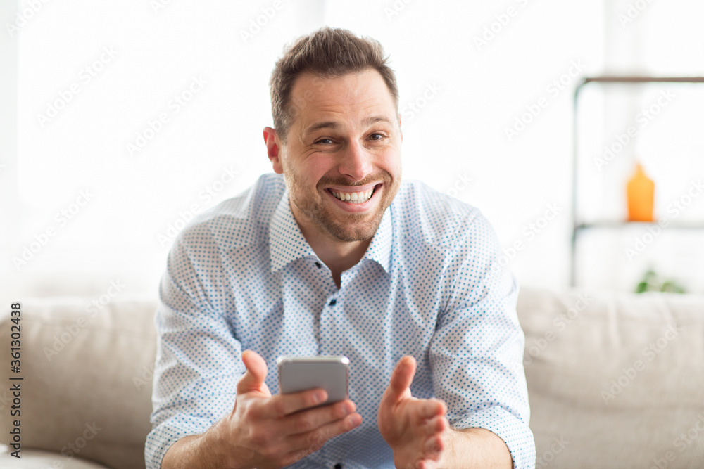 Excited adult man feeling ecstatic holding cell phone Excited adult man feeling ecstatic holding cell phone