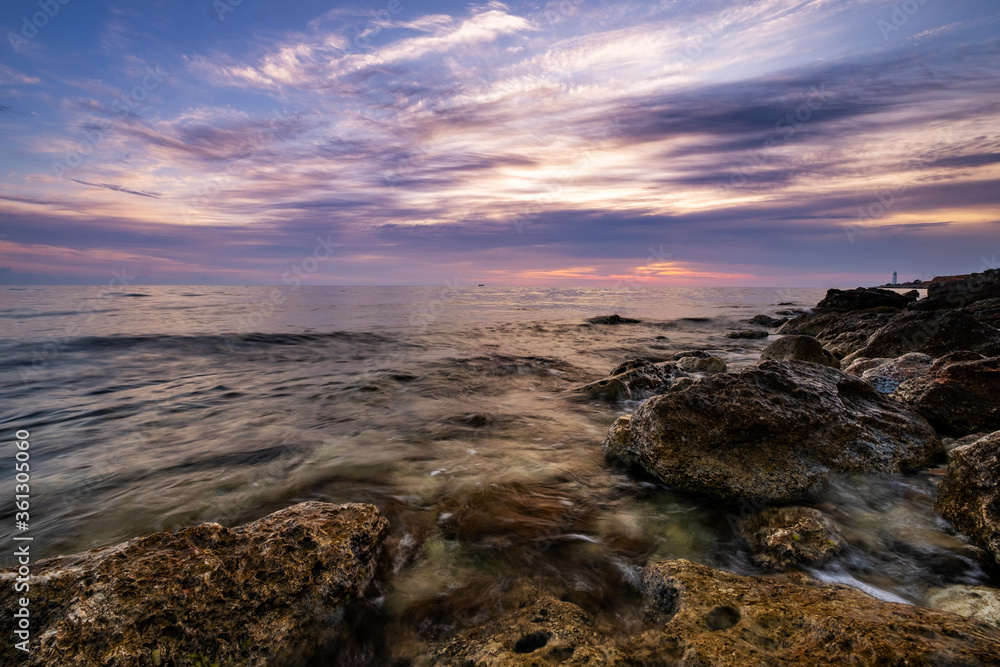 Obraz premium Dramatic sunset over beach with a natural pond in the foreground.