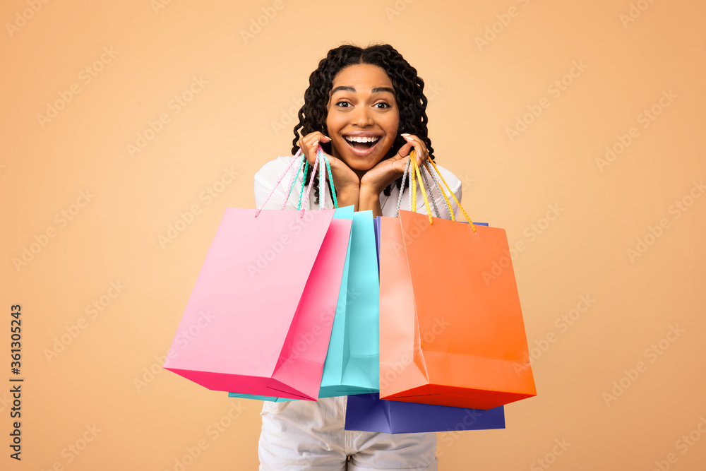 Excited Shopaholic Woman Holding Shopping Bags On Beige Studio Background Excited Shopaholic Woman Holding Shopping Bags On Beige Studio Background