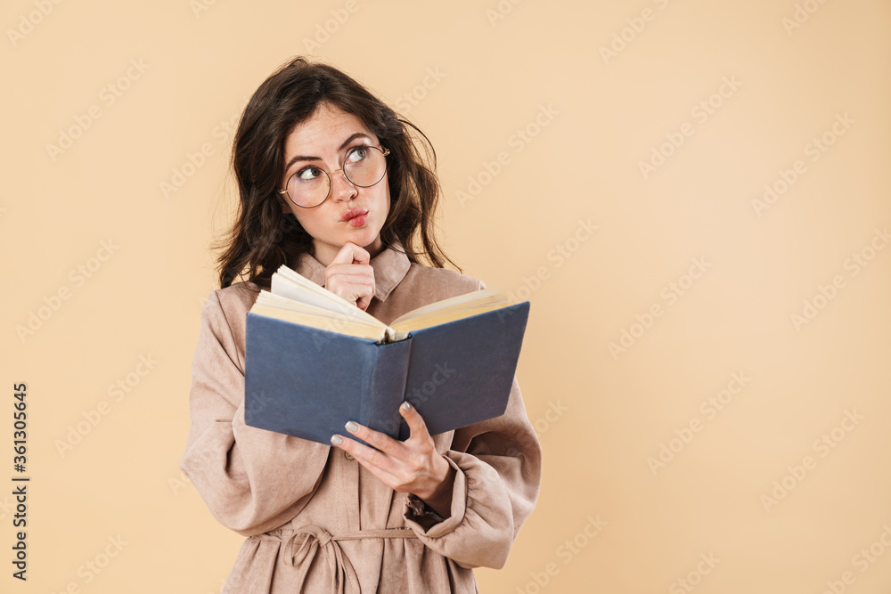 Image of thinking caucasian woman in eyeglasses reading book Image of thinking caucasian woman in eyeglasses reading book