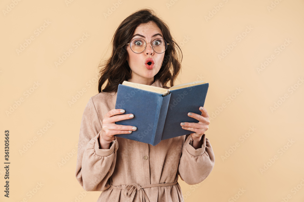 Image of surprised caucasian woman in eyeglasses reading book