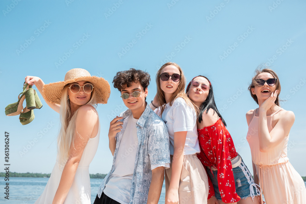 Picnic on the beach. Young, shiny. Seasonal feast at beach resort. Group of friends celebrating, resting, having fun in sunny summer day. Look happy, cheerful. Festive time, wellness, holiday, party. Picnic on the beach. Young, shiny. Seasonal feast at beach resort. Group of friends celebrating, resting, having fun in sunny summer day. Look happy, cheerful. Festive time, wellness, holiday, party.