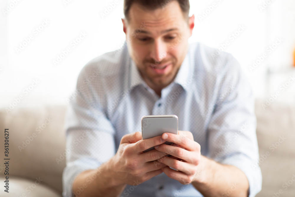 Handsome adult man using smart phone at home Handsome adult man using smart phone at home