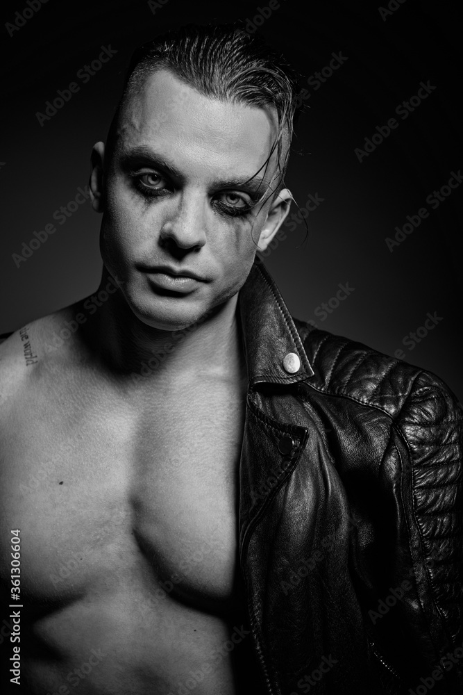 A man with embossed muscles and a naked torso in a leather jacket
