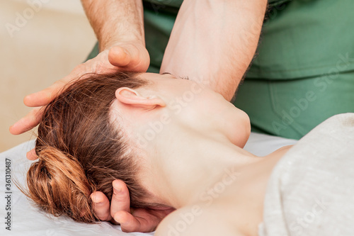 Head massage of woman by hands of massage therapist close up.