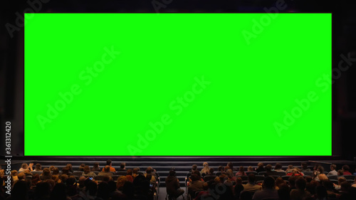 Obraz na plátně Viewers sitting in front of a big chroma key screen in the auditorium