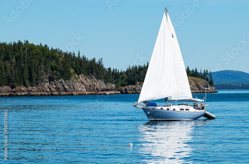 Sailboat in Frenchman Bay with porcupine islsnd in background by Bar Harbor Maine