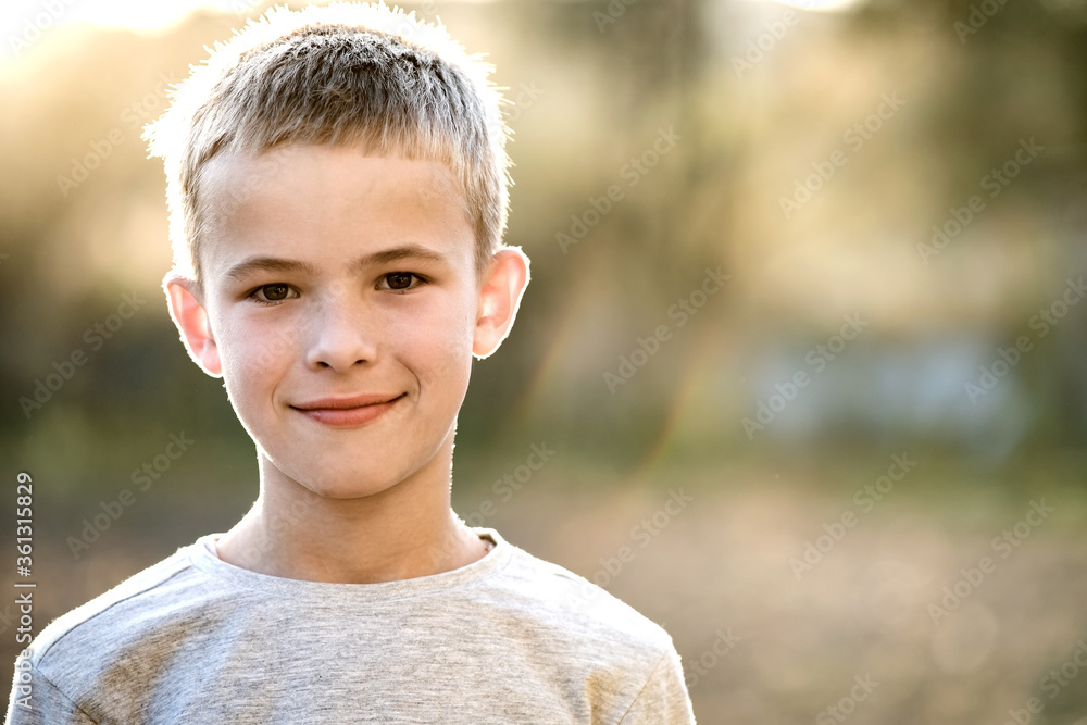Portrait of a child boy outdoors on a warm sunny summer day. - obrazy, fototapety, plakaty 