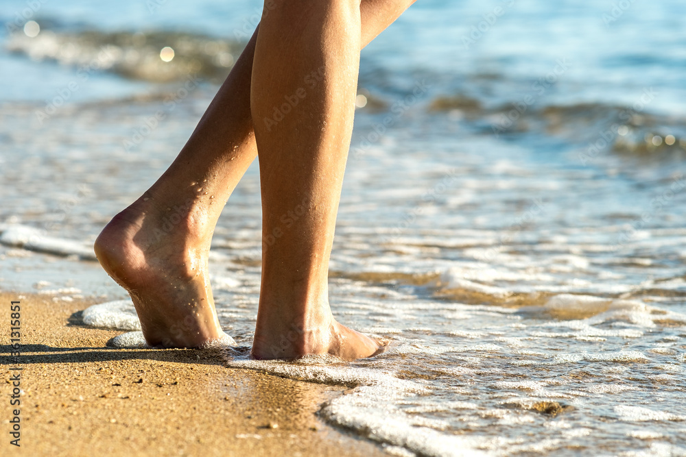 Close up of woman feet walking barefoot on sand leaving footprints on golden beach. Vacation, travel and freedom concept. People relaxing in summer. Close up of woman feet walking barefoot on sand leaving footprints on golden beach. Vacation, travel and freedom concept. People relaxing in summer.