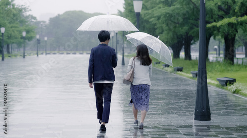 雨の日に傘を差してデートするカップル photo