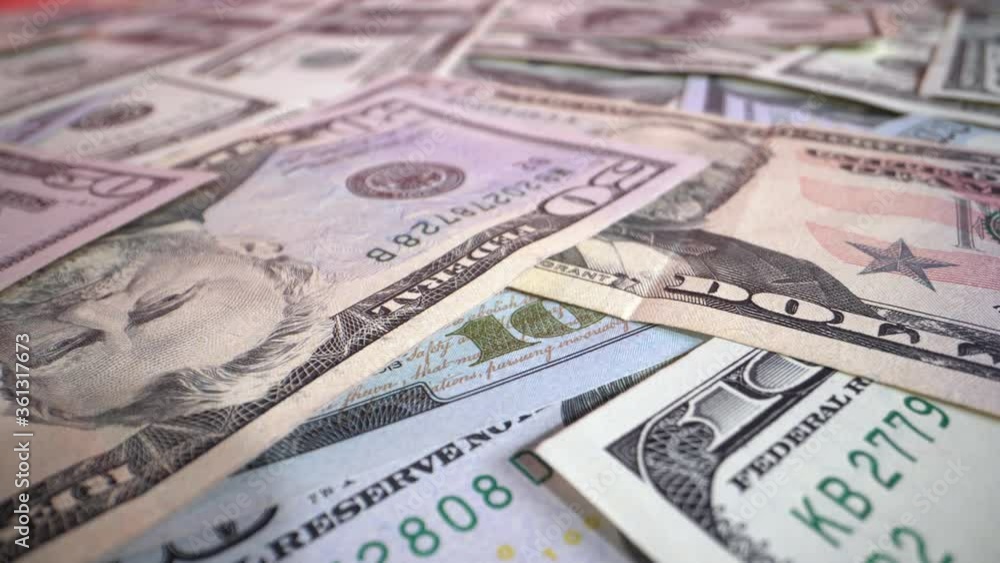 Dollar bills on the table rotate in front of the camera