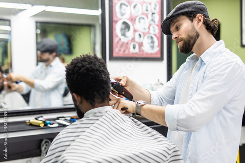 Young African-american man visiting barbershop cut hair