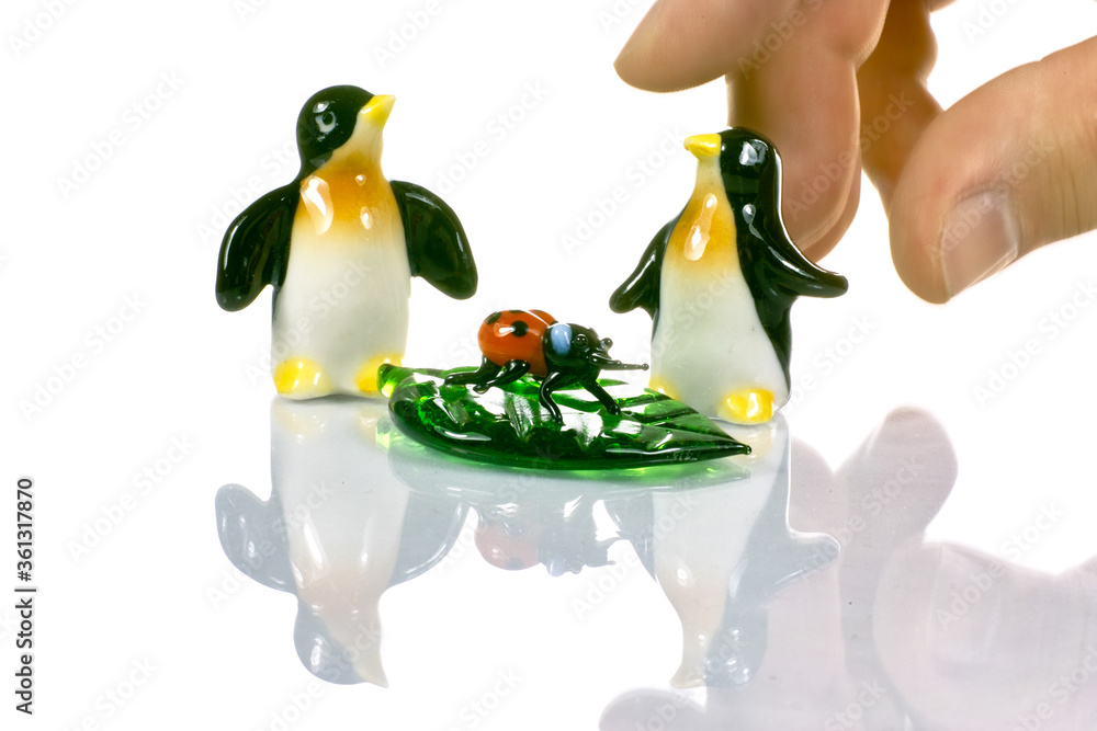 Fototapeta premium Two penguins ladybug and a master's hand ceremony.
