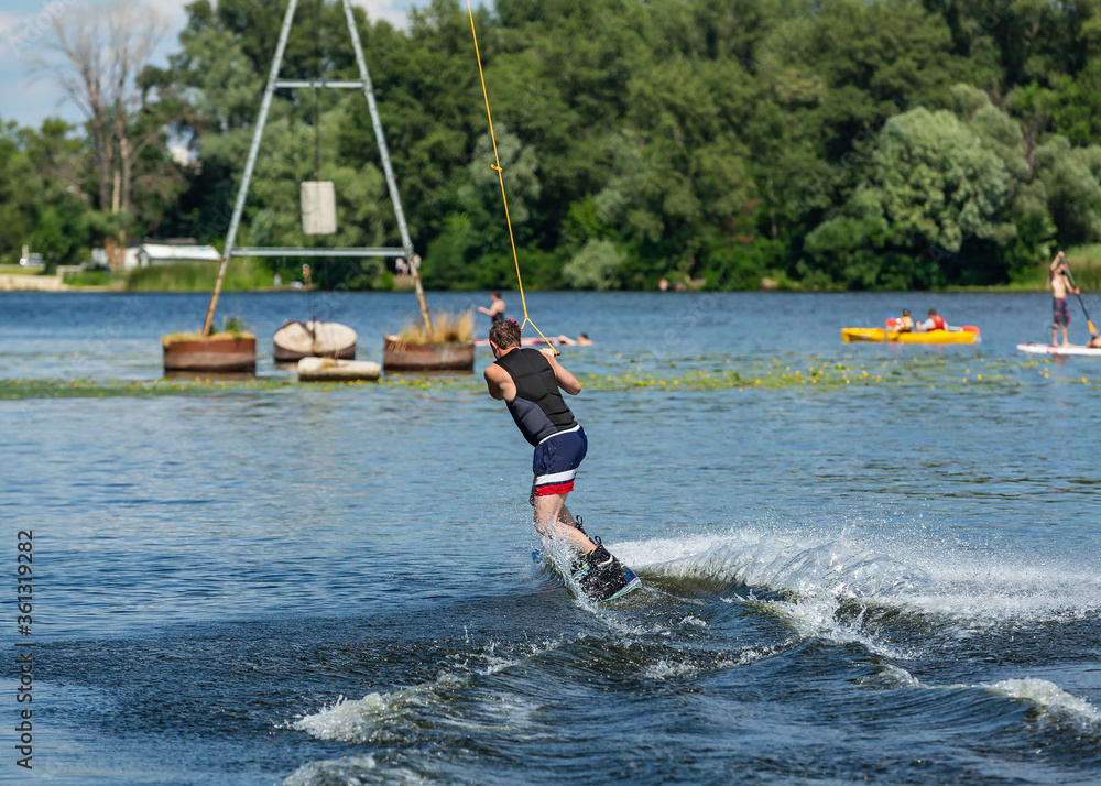 Naklejka premium Wakeboard. Man surfing on the river on a board