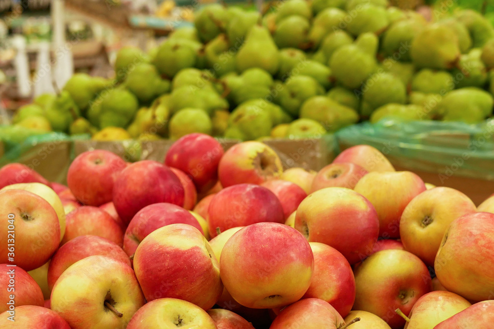 A pile of red apples lies in a drawer in a supermarket. A close-up red apples counter in a store waiting for buyers. A pile of red apples lies in a drawer in a supermarket. A close-up red apples counter in a store waiting for buyers.