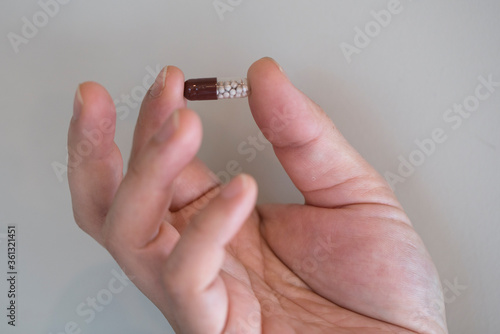 male hand holding pill isolated. healthcare and medical concept.