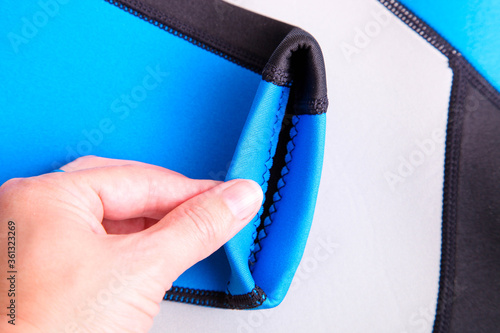 Female hand checks the thickness of the material neoprene closeup.