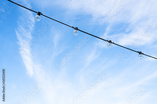 LED round light bulbs against the blue sky in the afternoon on the rope